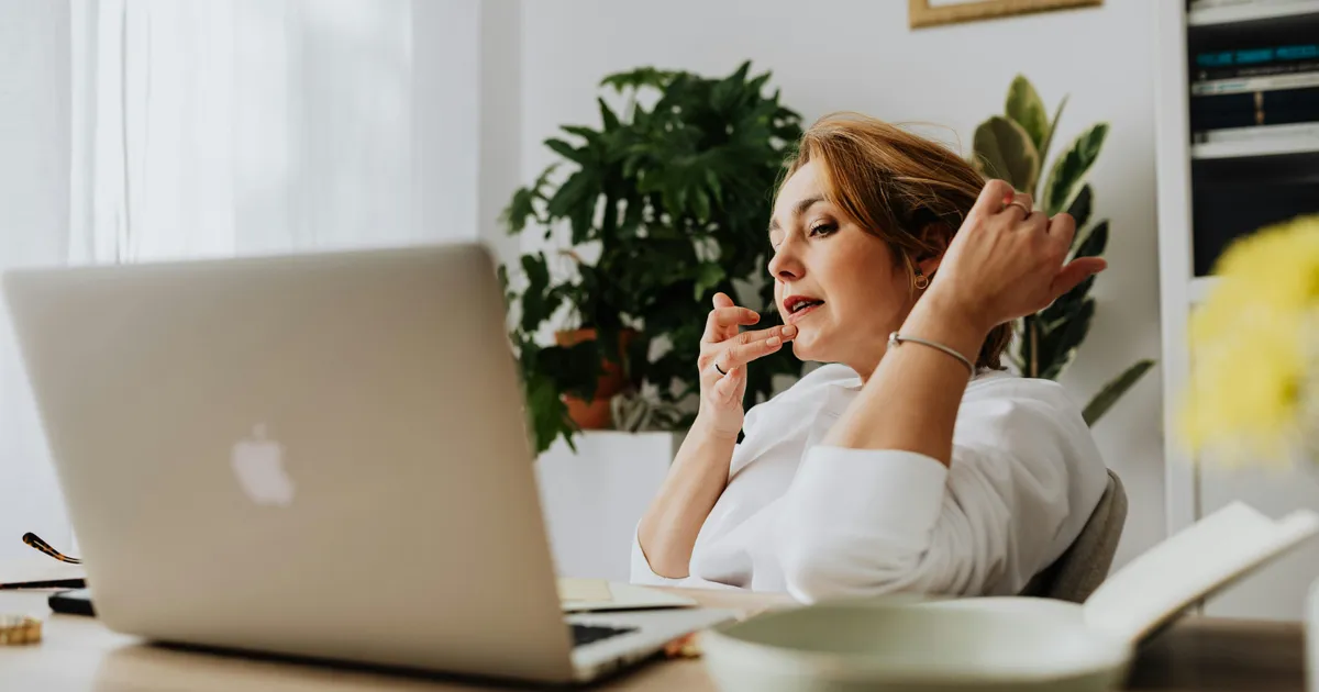 Person working from home on a laptop with a focused expression.